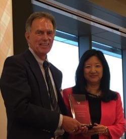 PAA President Gary Harris presents the Distinguished Alumni Award to Nanci Murphy in May 2016