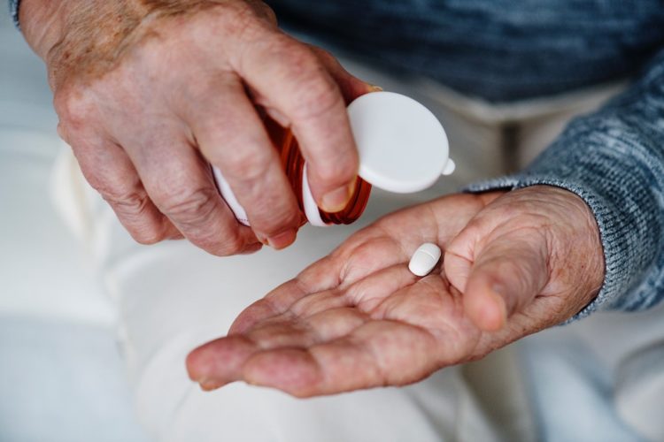 Older adult hands holding medication